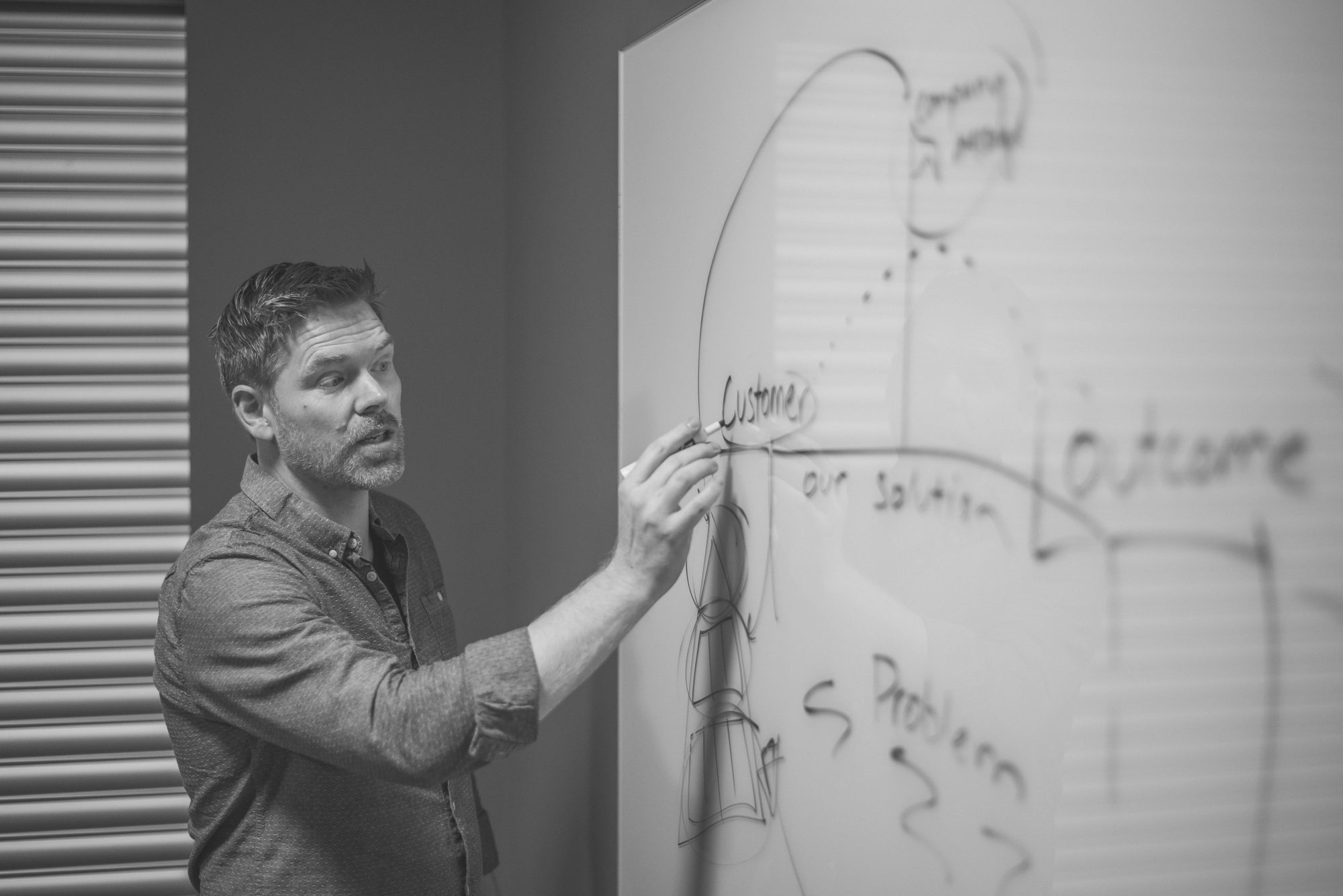 Josh Brammer working through an idea on a whiteboard
